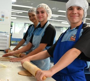 A photo of three Tranby students making gingerbread in the food technology labs.